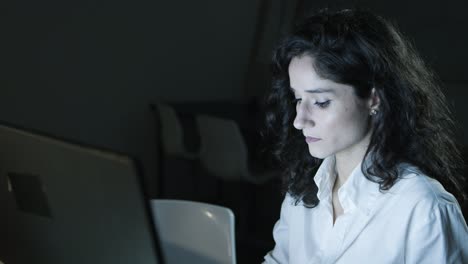 Fokussierte-Geschäftsfrau,-Die-Computer-Im-Dunklen-Büro-Benutzt